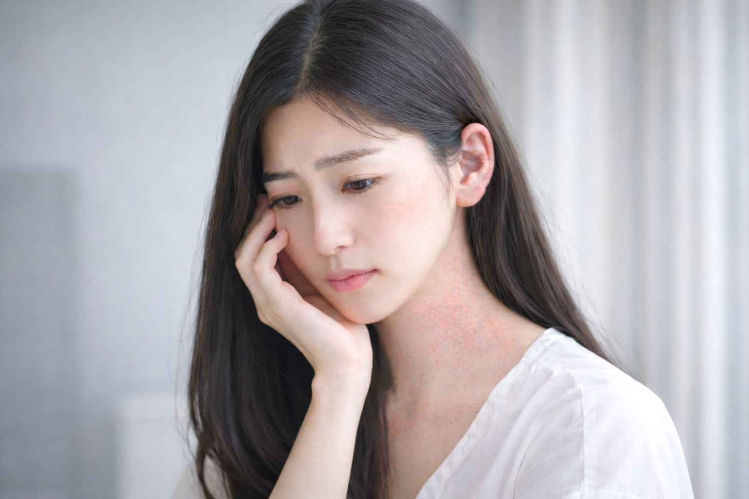 亞洲年輕女性頸部及耳後出現輕度濕疹症狀，表現出因皮膚問題而感到困擾的神情